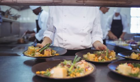 Chef keeping appetizer plate ready on the order station at restaurant