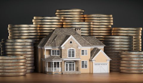 Real estate investments and mortgage concept. House and stack of